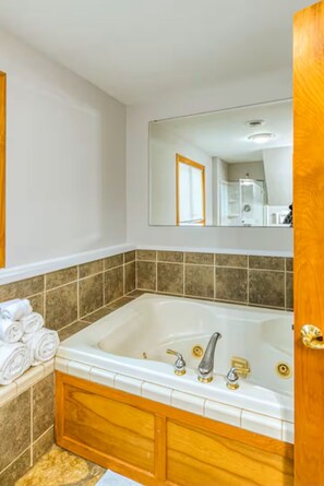 Douche, baignoire à remous, séchoir à cheveux, serviettes fournies