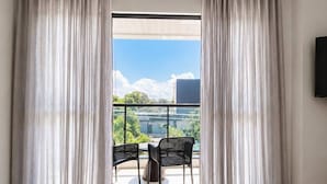 Une pièce dotée d’une grande porte-fenêtre coulissante qui donne sur un balcon extérieur avec deux chaises.