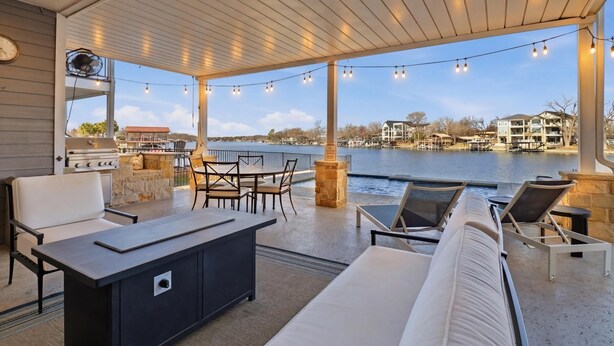 A covered outdoor area with a grill, seating, and a view of the water. - GiGi's Jewel | Lakefront+ Pool+ Pet Friendly +Lift (Kingsland)
