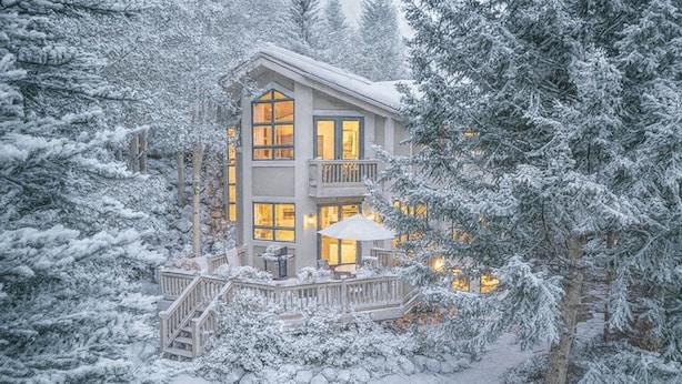 A multi-story lodge with a balcony, surrounded by snow-covered trees. - Luxury Vail Mountain Estate – Ski Access • Spacious • Elegant Mountain Retreat (Vail)
