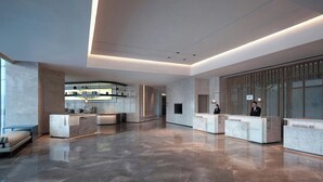 A spacious lobby with a reception desk, seating area, and a modern kitchen visible in the background. - Courtyard By Marriott Chongqing Jiangjin (Chongqing)