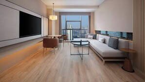 A modern living room with a sofa, a coffee table, and a TV mounted on the wall. - Courtyard By Marriott Chongqing Jiangjin (Chongqing)