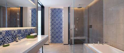A modern bathroom with a large mirror, two sinks, a glass-enclosed shower, and a bathtub.