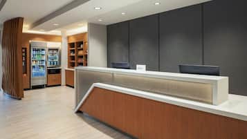A reception area with a counter, a refrigerator stocked with beverages, and shelves with snacks.