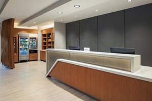 A reception area with a counter, a refrigerator stocked with beverages, and shelves with snacks. - Springhill Suites By Marriott Madison Fitchburg (Madison)