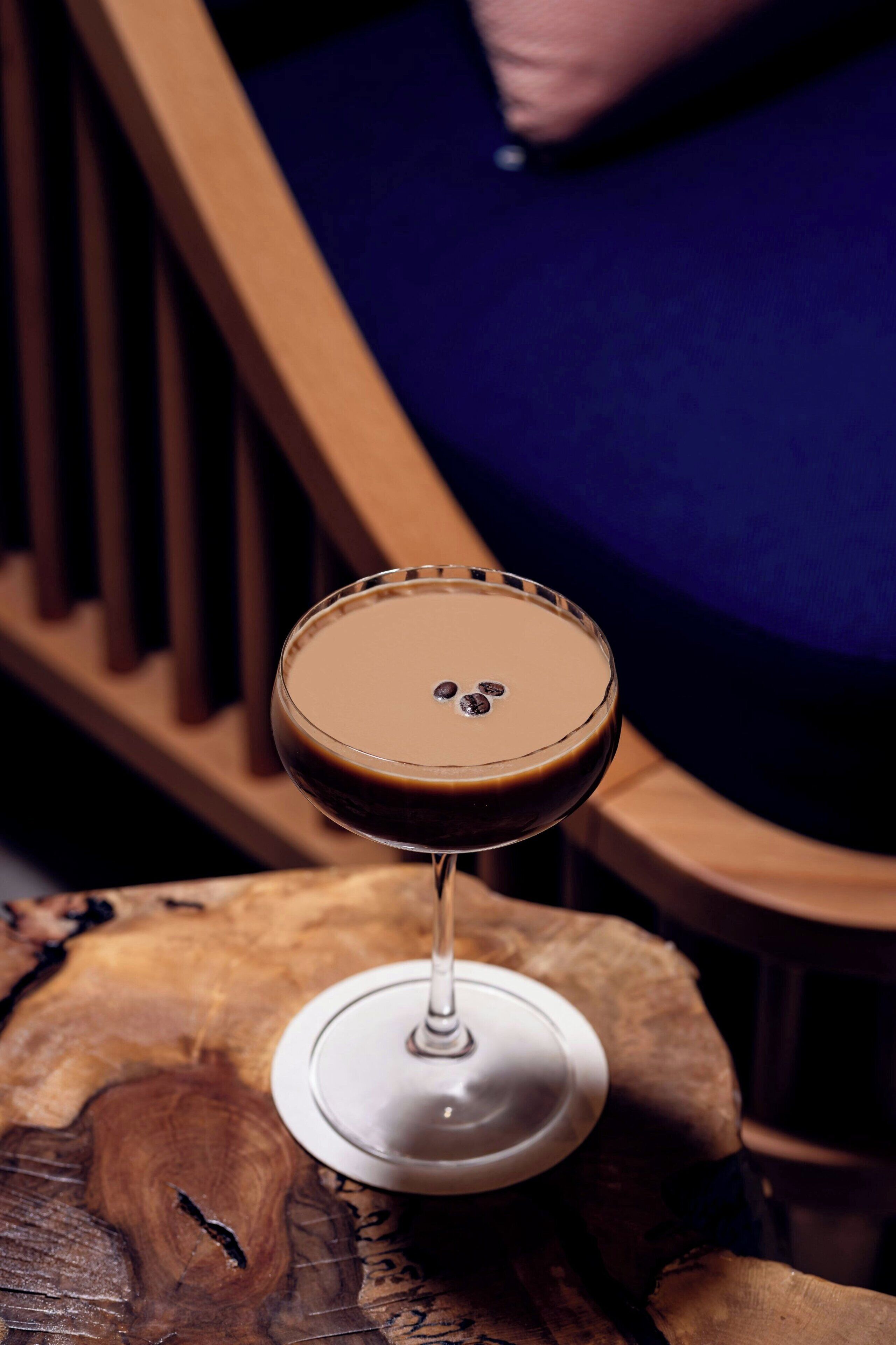 Een cocktailglas op een houten oppervlak met een onscherpe achtergrond.