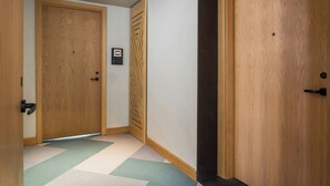 A hallway with wooden doors, a patterned floor, and a small framed picture on the wall. - Four Points By Sheraton São Vicente Resort (Mindelo)