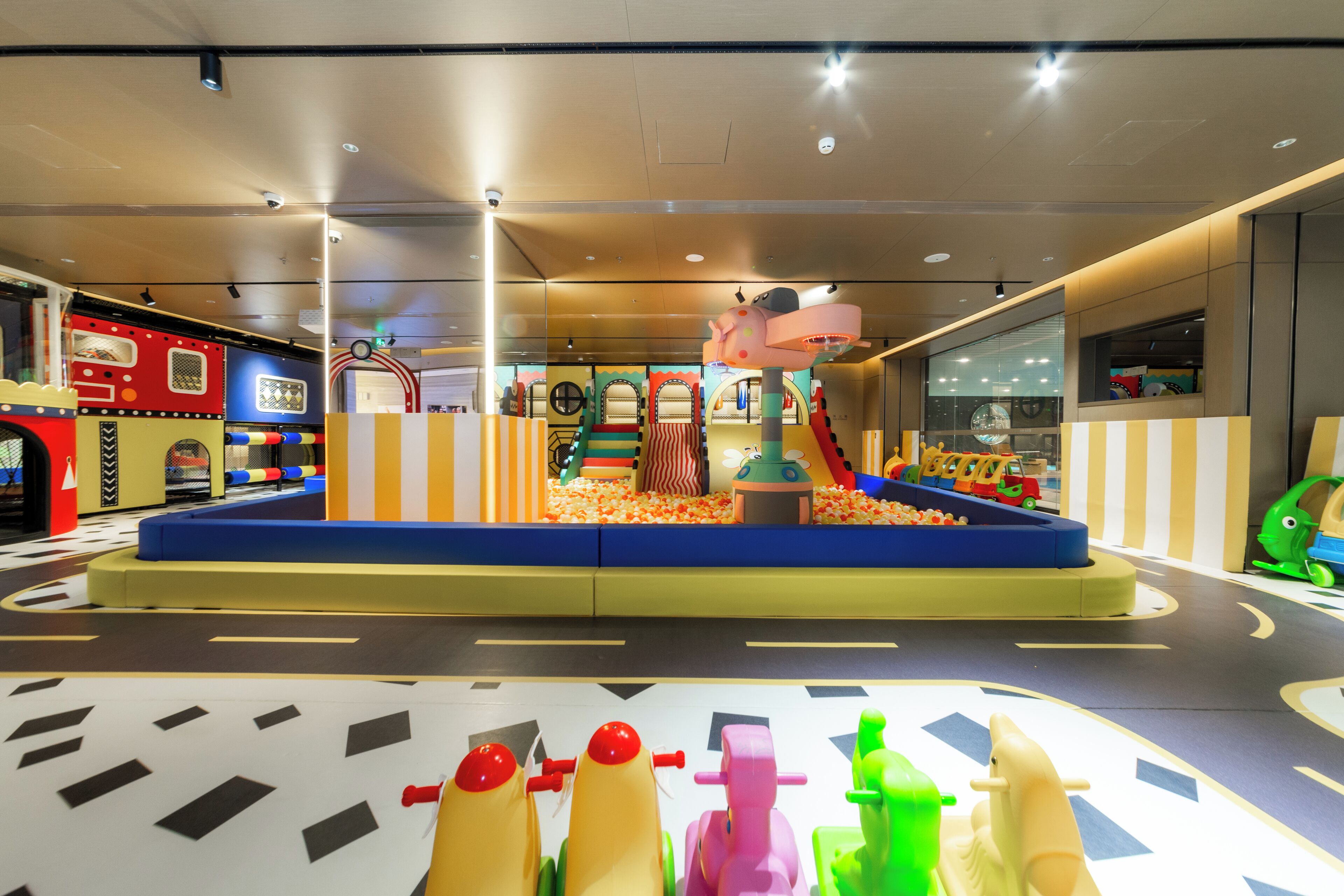 A children's play area with a ball pit, slides, and colorful play structures.