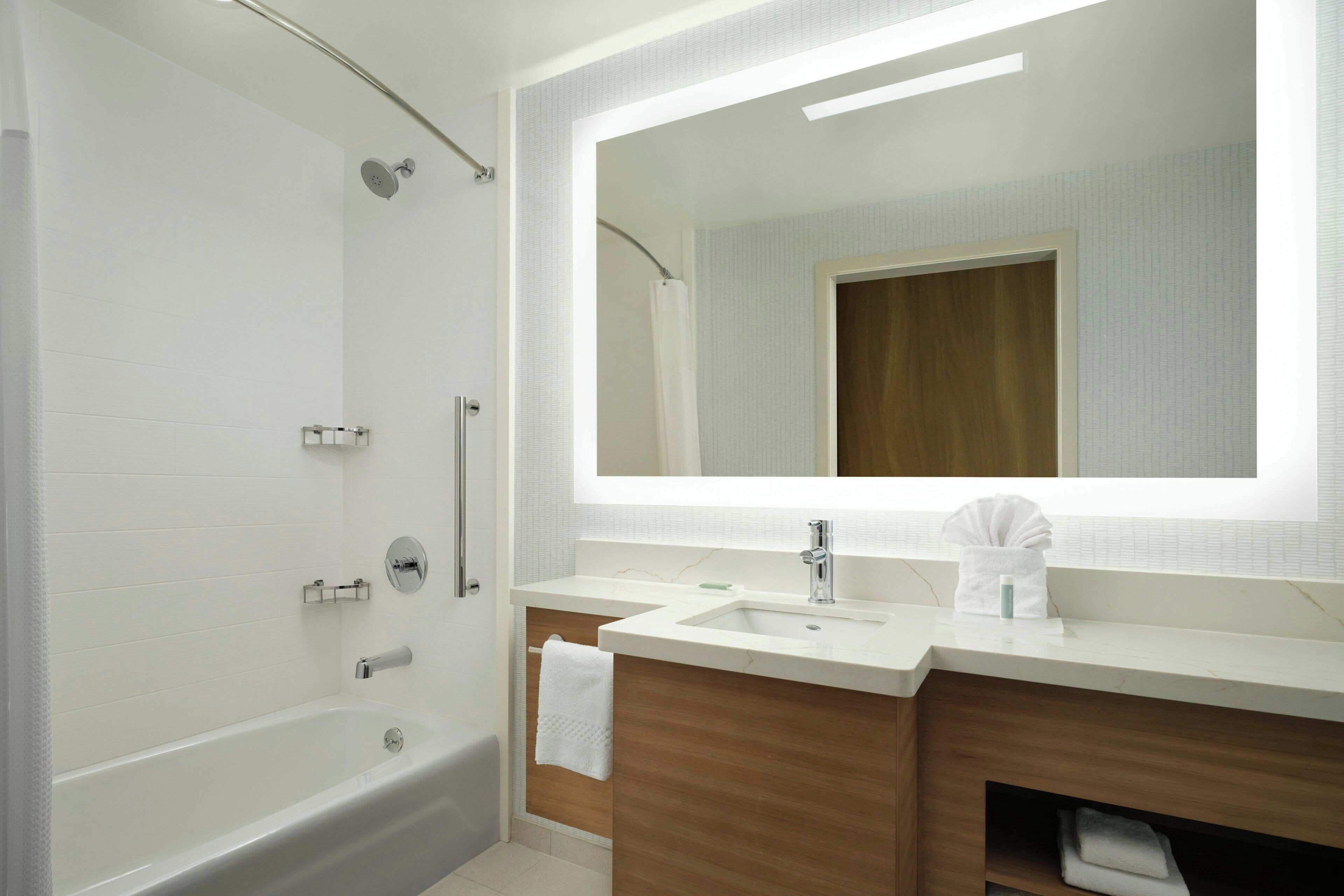 Une salle de bain moderne avec une baignoire, un lavabo et un grand miroir.