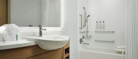 Un baño moderno con un lavabo grande, espejo, ducha y bañera.
