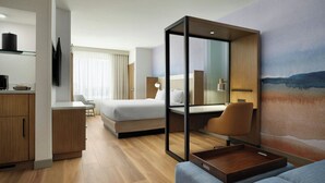 A modern hotel room with a bed, a seating area, a desk, and a TV. - Springhill Suites By Marriott Ventura Oxnard (Oxnard)
