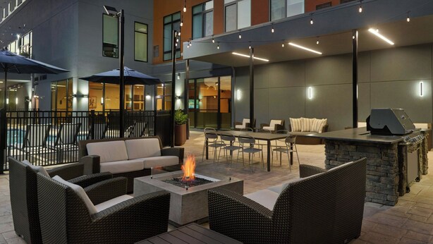 An outdoor patio with wicker furniture, a fire pit, and a grill area. - Residence Inn By Marriott Birmingham Grandview (Birmingham)