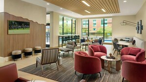A modern lounge area with seating, a large window, and a wall-mounted painting. - Residence Inn By Marriott Birmingham Grandview (Birmingham)