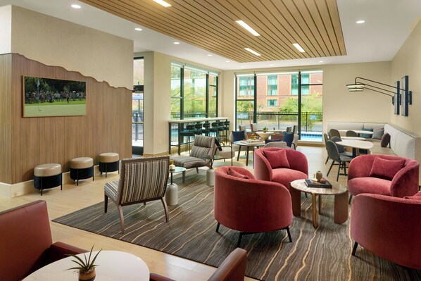 A modern lounge area with seating, a large window, and a wall-mounted painting. - Residence Inn By Marriott Birmingham Grandview (Birmingham)