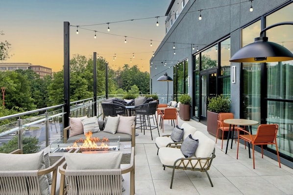 An outdoor seating area with fire pit, chairs, and tables, overlooking a cityscape. - Residence Inn By Marriott Birmingham Grandview (Birmingham)
