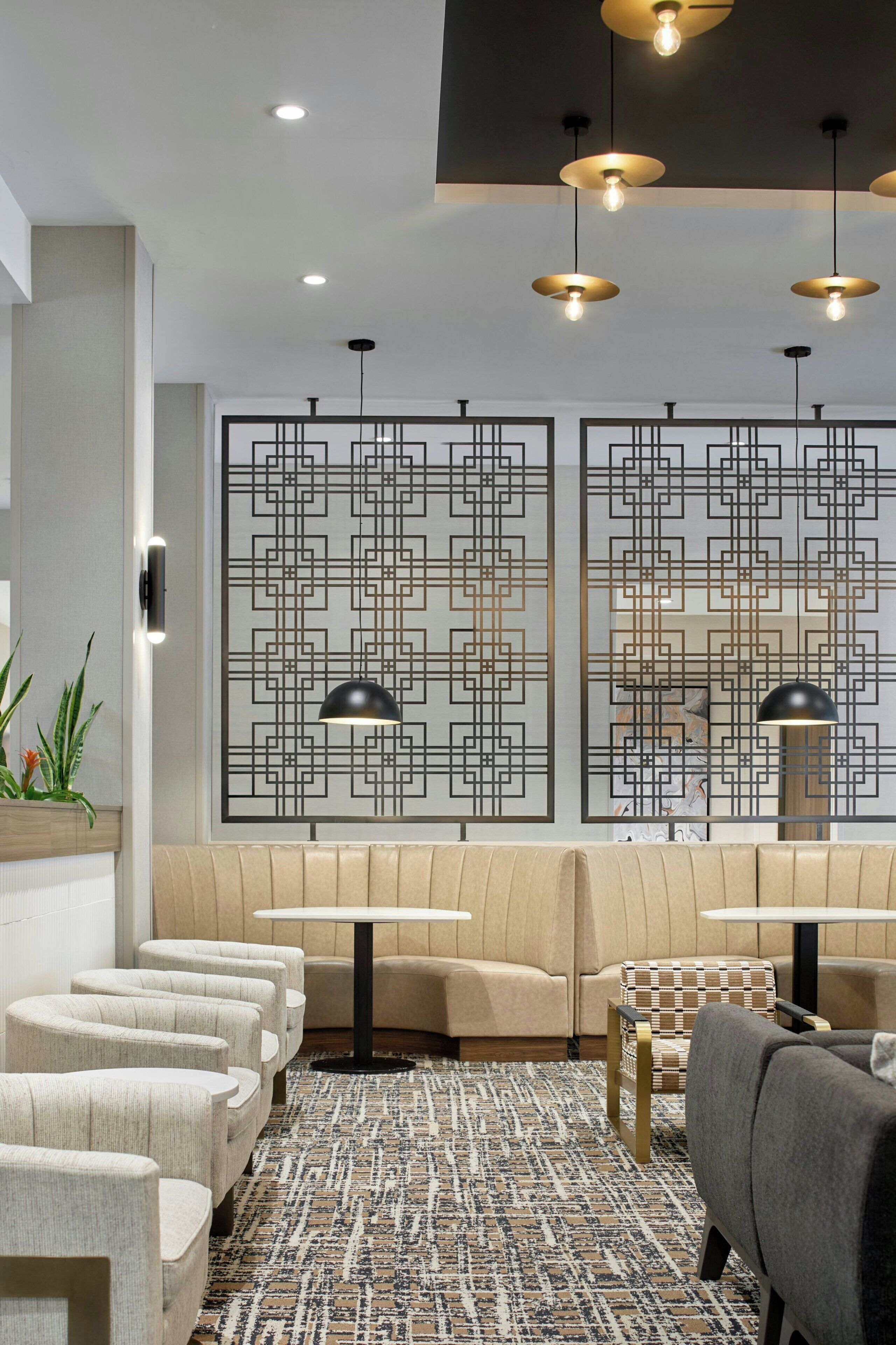 A modern lounge area with seating, pendant lighting, and decorative wall panels.