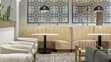 A modern lounge area with seating, pendant lighting, and decorative wall panels.