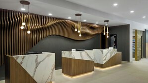 A reception area with marble counters, wooden paneling, and pendant lighting. - Residence Inn By Marriott Birmingham Grandview (Birmingham)