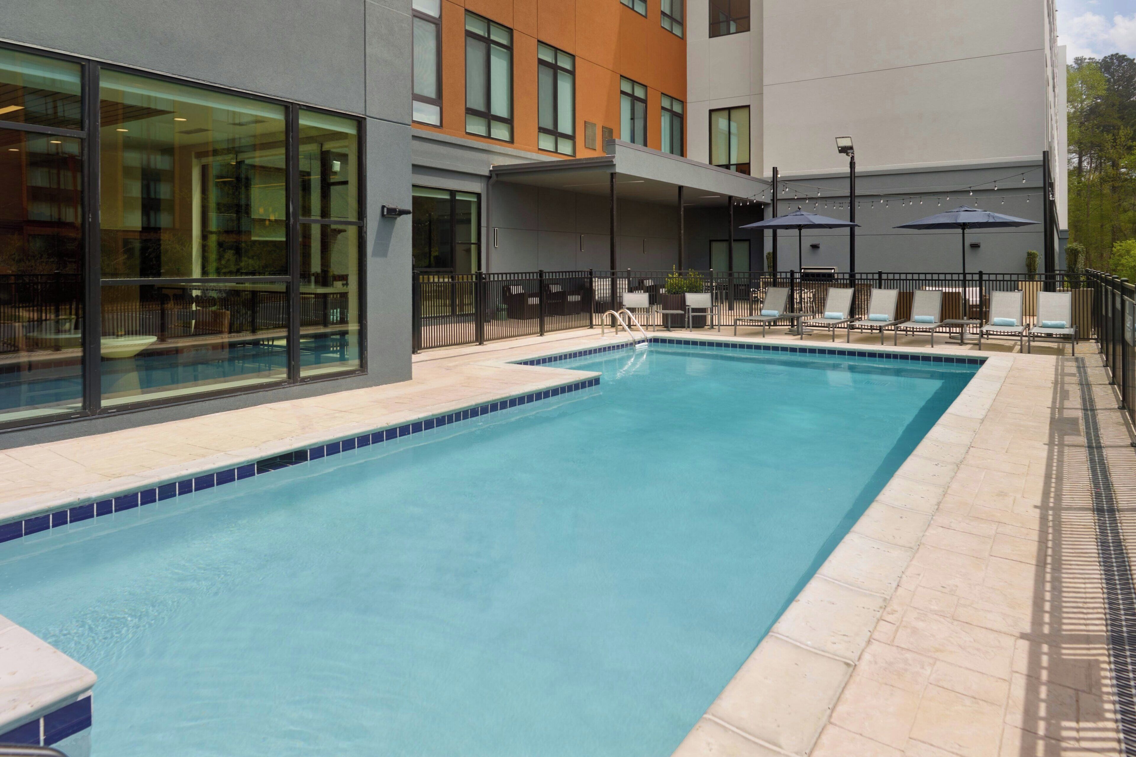 Una piscina al aire libre de temporada, sillones reclinables de piscina