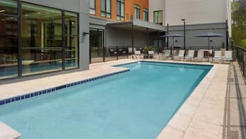 Una piscina al aire libre de temporada, sillones reclinables de piscina