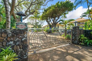 A gated entrance to a private property with a stone wall, a sign reading "LAE NANI PRIVATE PROPERTY", and a metal gate. - Beachfront Ocean View Oasis w/Saltwater Pool (Kapaʻa)