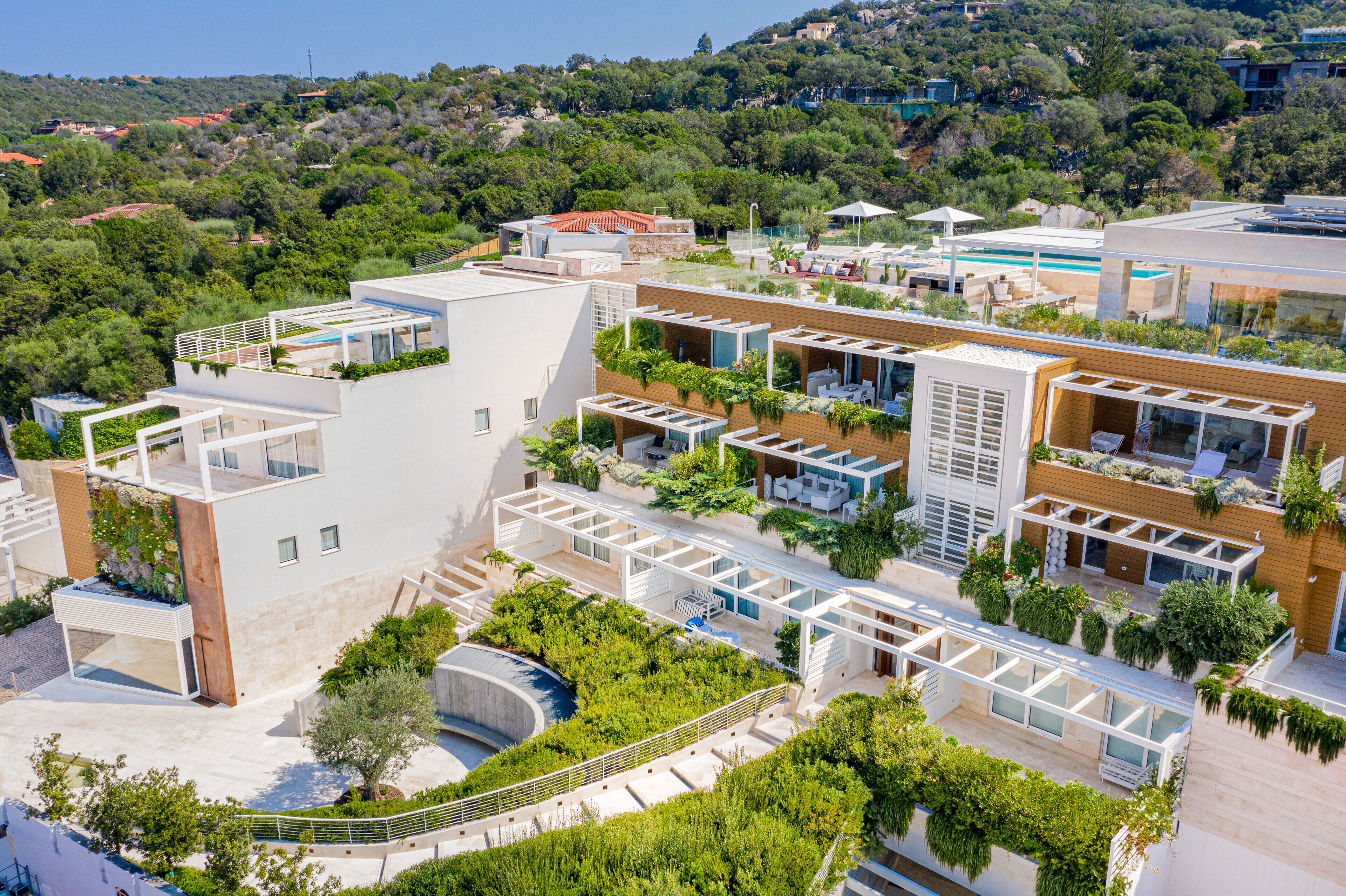 A modern hotel with multiple levels, outdoor terraces, and a pool area.