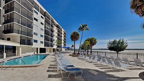 Un hôtel moderne doté d’une piscine, de chaises longues et de palmiers.