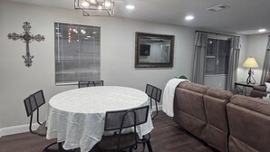 A dining area with a round table, chairs, a sofa, and a lamp. -  The Happy Place, a Charming & Cozy 3-bedroom home in the heart of Sneads, FL. (Sneads)