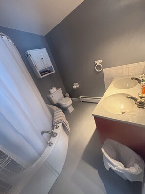 A bathroom with a bathtub, toilet, and sink. - Cozy 3-Bedroom Mountain Style Home (Reading)