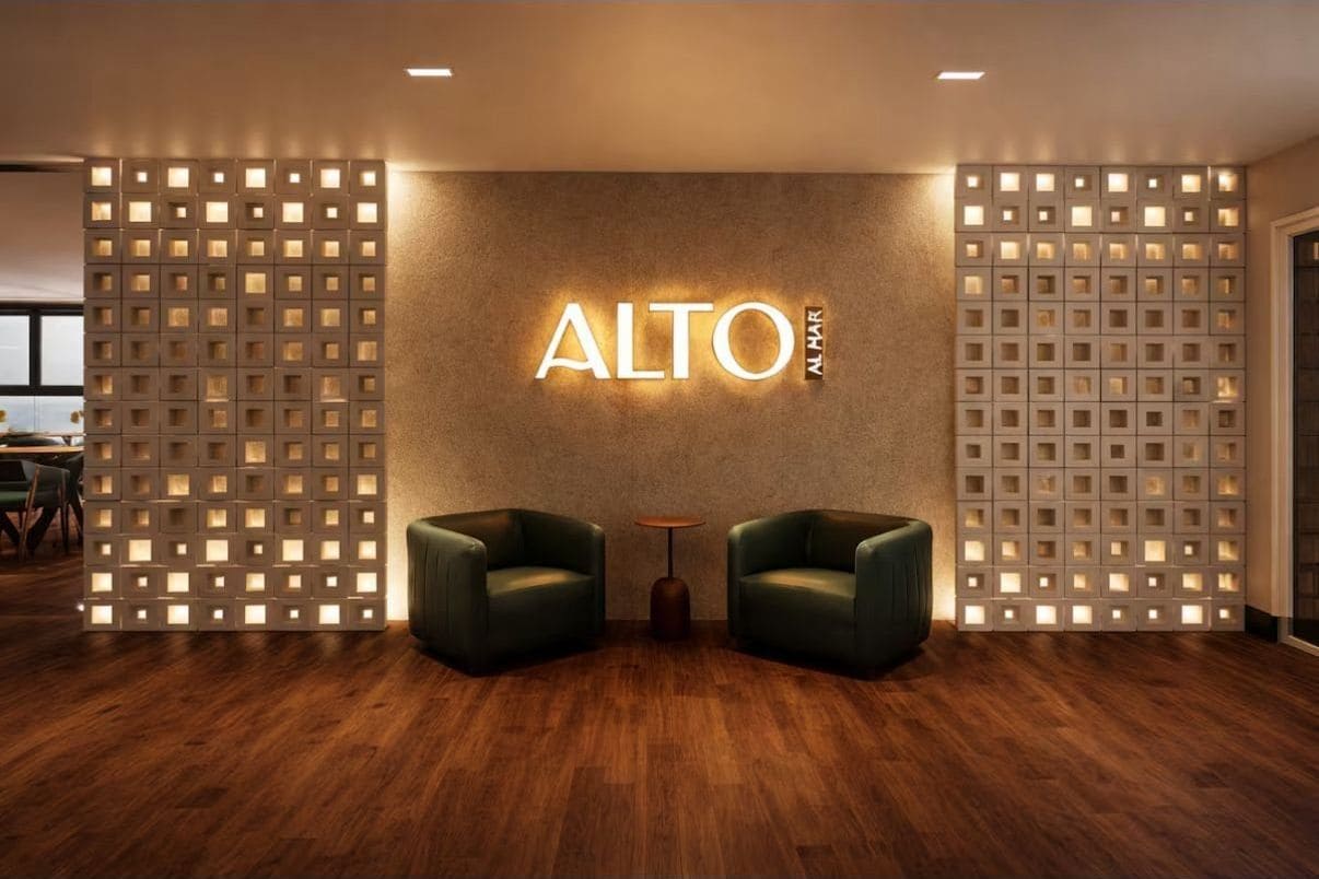 A modern interior with a wall-mounted sign reading 'ALTO N.A.R.' and two leather chairs in front.