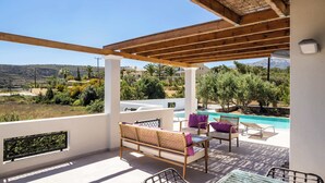 Un espacio al aire libre cubierto con piscina, asientos y vistas al paisaje.