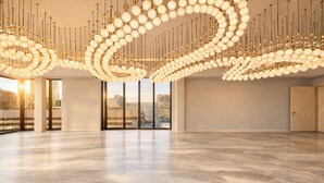 A spacious, modern hotel lobby with a high ceiling and a unique spherical chandelier design. - Denu Hotel & Spa (Phoenix)