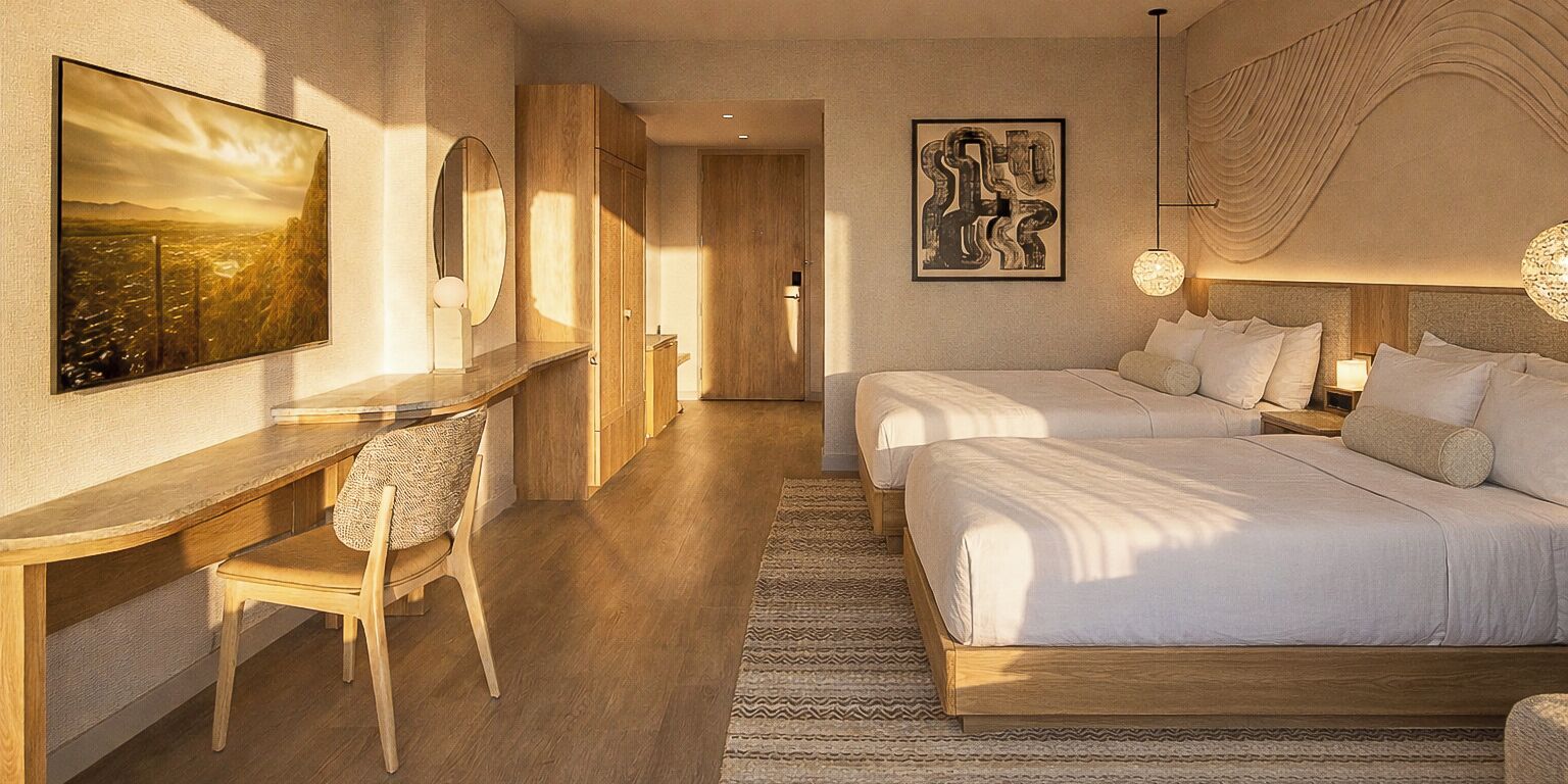 Habitación de hotel con escritorio, dos camas, una silla y obras de arte en las paredes.