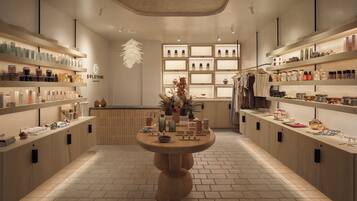 Un spa con estanterías de madera, una mesa central y una lámpara decorativa en el techo.