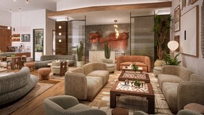 A modern living room with sofas, a coffee table, and a fireplace. - Denu Hotel & Spa (Phoenix)