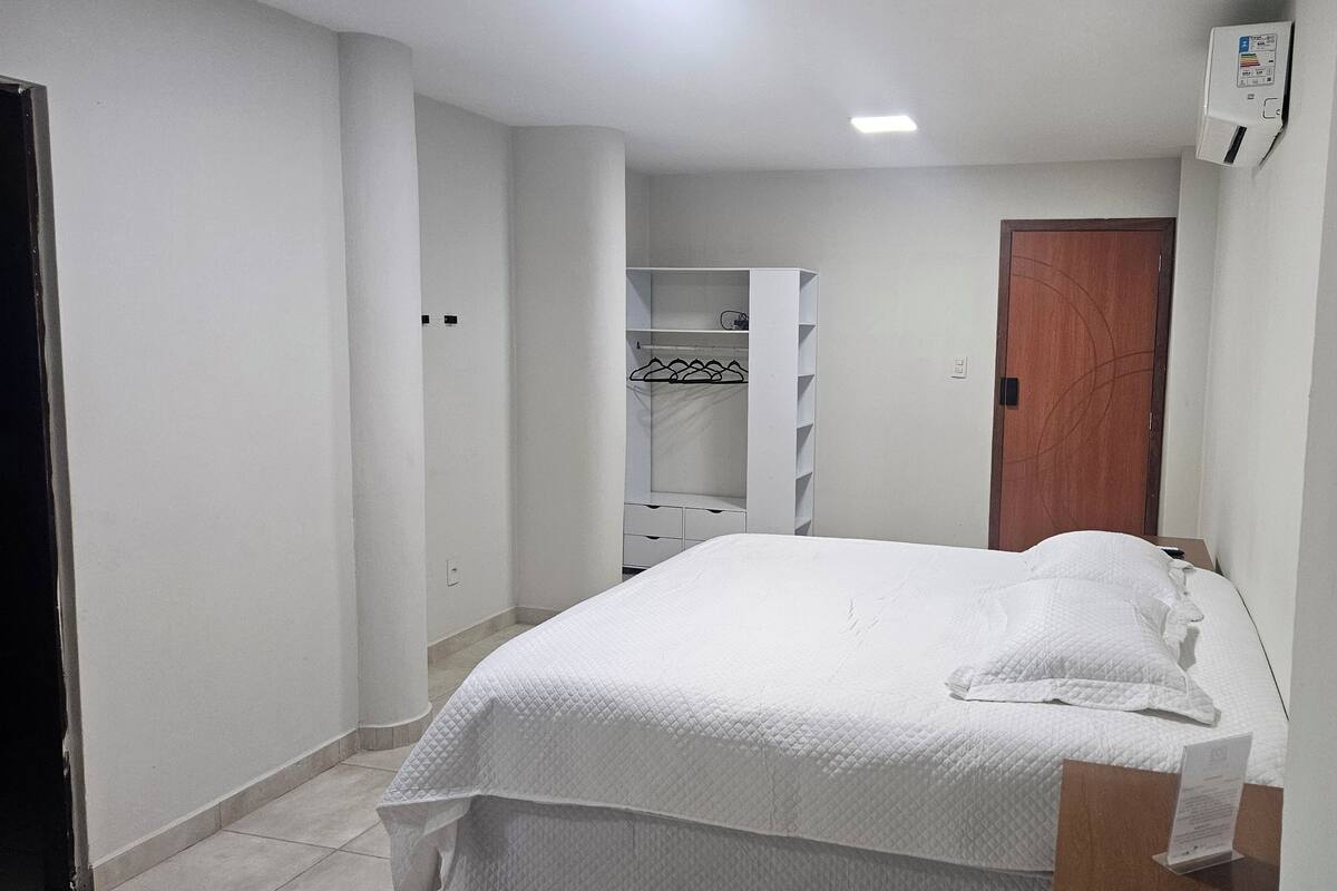 A bedroom with a bed, a wardrobe, and a door.