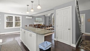 A kitchen with a central island, pendant lighting, and a view of the dining area. - Family-Friendly Mashpee Retreat w/ Outdoor Fun (Mashpee)