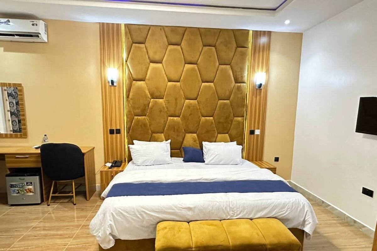 Una habitación de hotel con una cama grande, un escritorio y un cubo de basura.