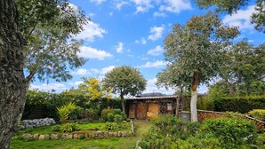 A rustic house surrounded by a well-maintained garden with various plants and trees. - "La Désirée" air-conditioned bastidon, private estate, swimming pool, pétanque, restaurant. (Fréjus)