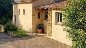A two-story house with a tiled roof, a stone pillar, and a gravel driveway. - "La Désirée" air-conditioned bastidon, private estate, swimming pool, pétanque, restaurant. (Fréjus)