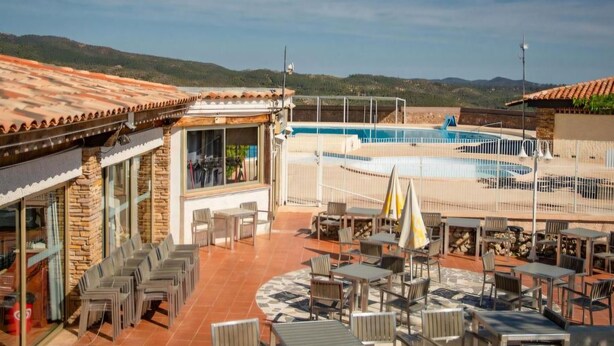 A rooftop pool area with outdoor seating and a view of the surrounding landscape. - "La Désirée" air-conditioned bastidon, private estate, swimming pool, pétanque, restaurant. (Fréjus)