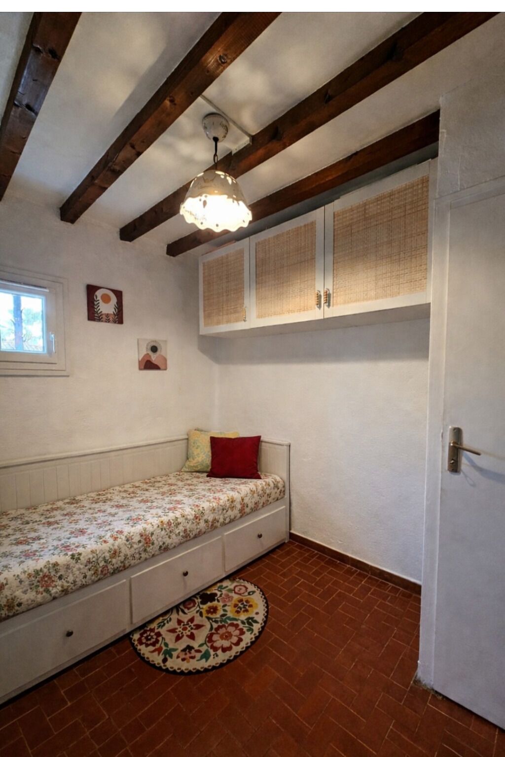 Ein Schlafzimmer mit Bett, Fenster, Tür und Deckenventilator.