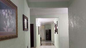 A hallway with light green walls, a tiled floor, and framed pictures on the walls. - Charming 3-bedroom house. located in San Jose Casas Caidas Mpio La Barca. (San Jose Casas Caidas Mpio La Barca)