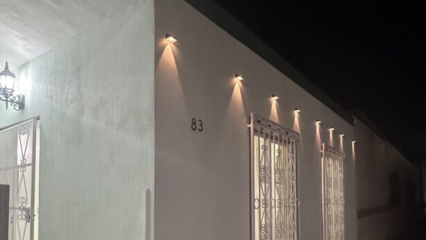 A building exterior at night with illuminated numbers '83' and decorative metal gates. - Charming 3-bedroom house. located in San Jose Casas Caidas Mpio La Barca. (San Jose Casas Caidas Mpio La Barca)