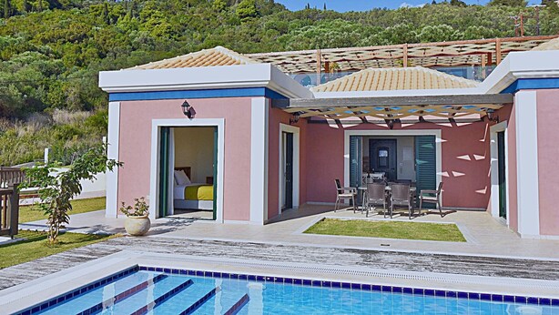 Una villa moderna con piscina, terraza cubierta y vistas a una colina exuberante.