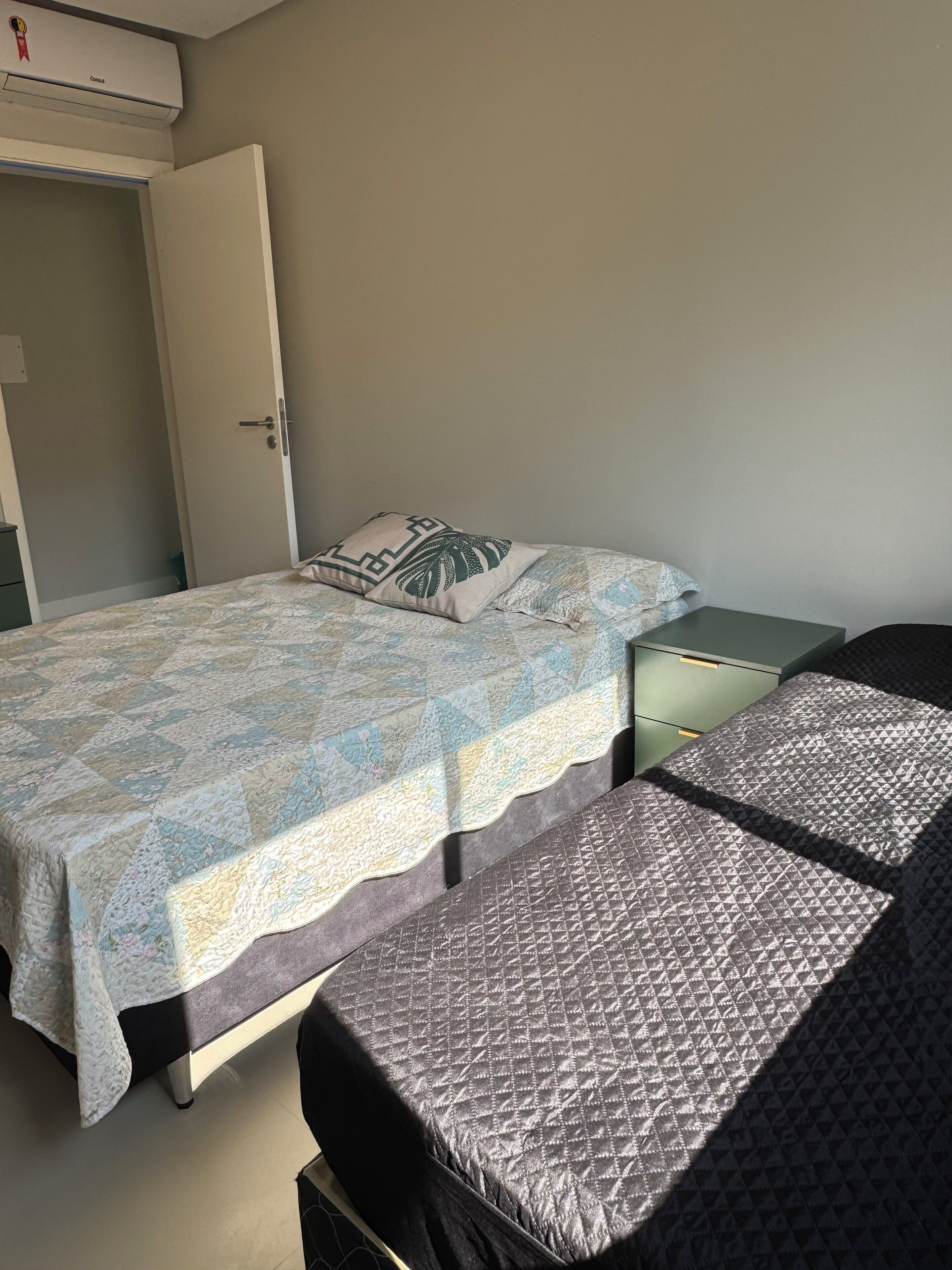 A bedroom with a bed, a nightstand, and a wardrobe.
