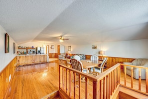 A spacious living area with a wooden floor, a dining table, and a sofa. - Cozy Barn Apt w/ 5-Acre Pond in South Georgia! (Doerun)