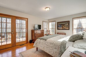 Ein Schlafzimmer mit einem großen Bett, einem Holzschrank und einem Fernseher auf einer Kommode.