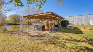 Un espace extérieur abrité avec des sièges, un barbecue, un bassin et un bâtiment en arrière-plan.