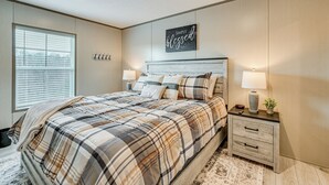 A bedroom with a bed, bedside tables, a wall-mounted sign, and a window. - Cozy Hillside Retreat Near Dale Hollow Lake! (Burkesville)